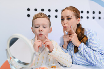 Child receiving speech therapy with adult specialist