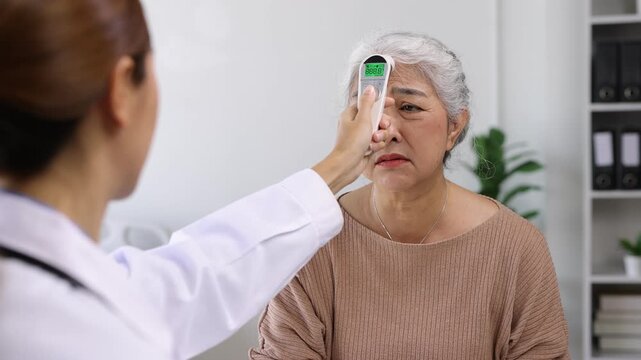 Doctor measuring temperature of a senior patient with fever.