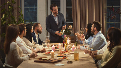 Man presenting wine bottle to friends at dinner table. Concept of hosting culture, wine education, lifestyle marketing, premium beverage positioning and social dining experiences.