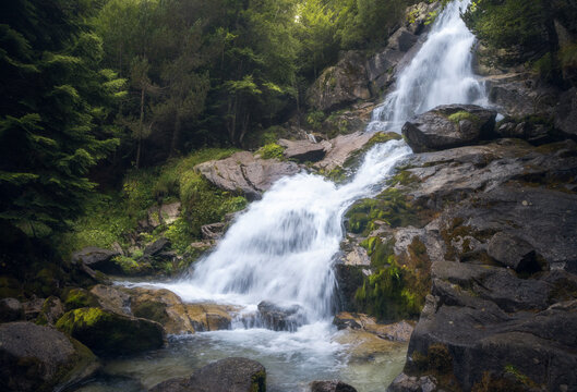 Molieres waterfall cascades through lush greenery in Vall d'Aran, Catalonia