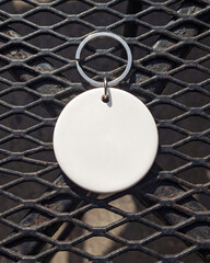 Blank round tag against metal grid with a transparent background