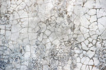 Cracked surface texture of the concrete wall of the house