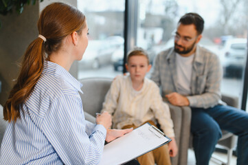 Fototapeta premium Psychologist counseling father and son during family therapy session