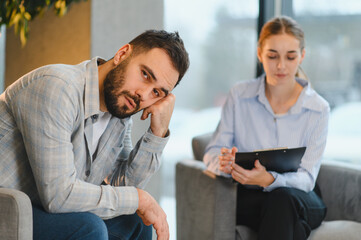 Fototapeta premium Man feeling depressed attending mental health therapy session