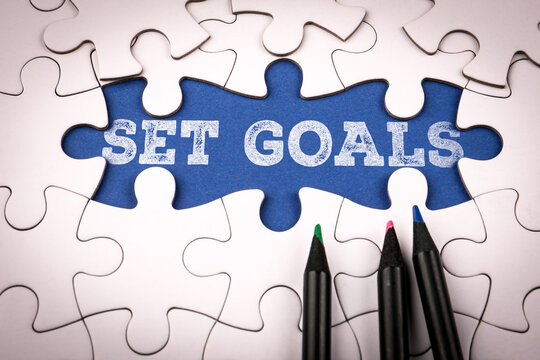SET GOALS Planning Concept With Puzzle Pieces And Color Pencils