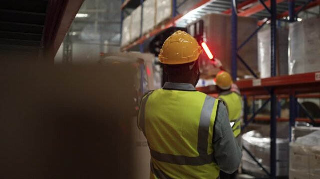 Blue collar workers are working at warehouse. Logistics, transportation.