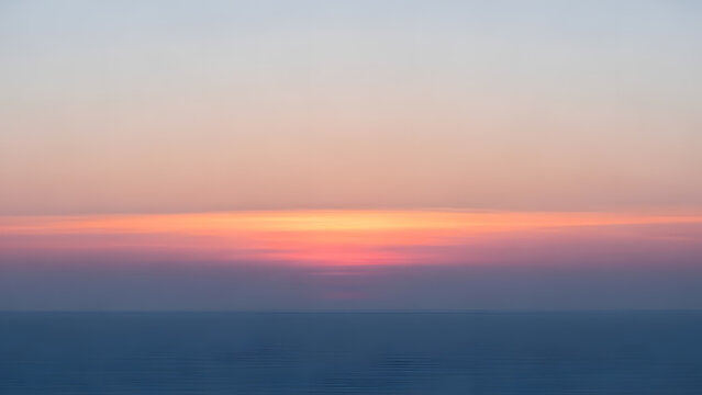 A calm sea horizon under a soft pink and blue gradient sky during sunset - Powered by Adobe