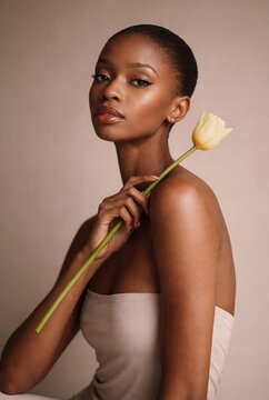 Beautiful african woman holding yellow tulip flower