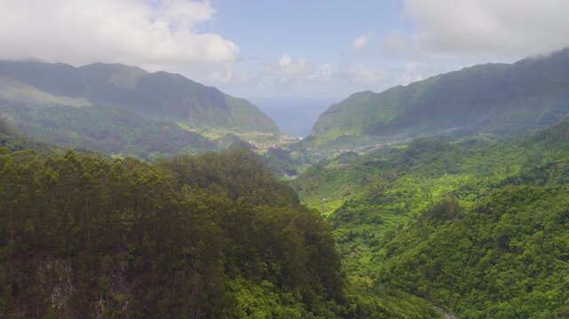 4K video; Slow forward drone flight over a lush green valley towards the village of Sao Vicente at the north coast of the island of Madeira