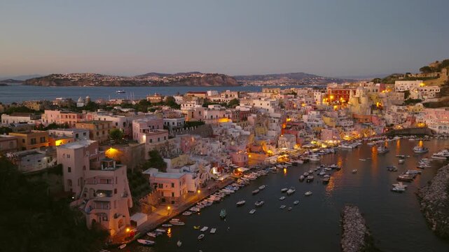 Stunning aerial view of Procida, Italy at dusk showcasing vibrant architecture and serene waters.
