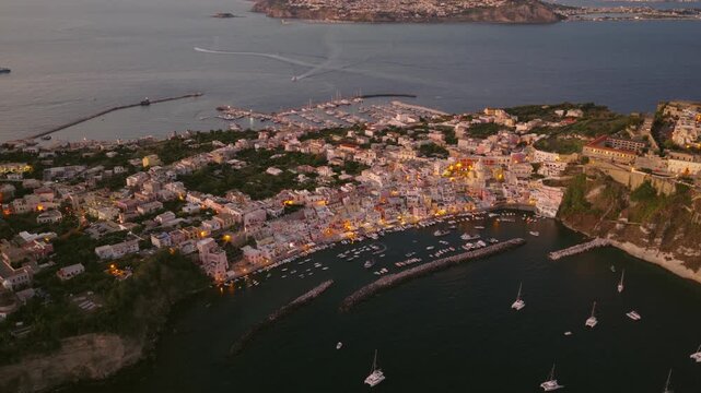 Stunning aerial footage showcasing the vibrant coastal town of Procida, Italy at dusk.