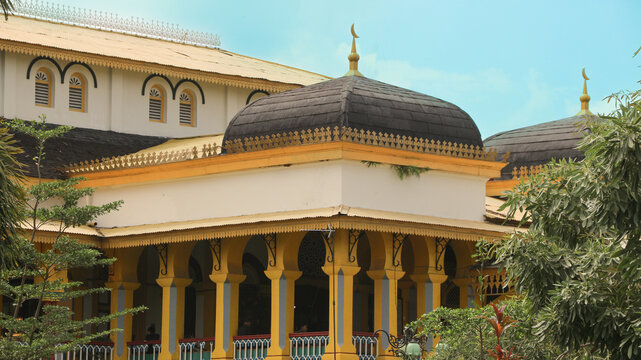 Medan, Indonesia - October 6, 2025: The magnificent architecture of Maimun Palace in Medan, Indonesia, showcases its iconic yellow color and unique blend of Malay, Islamic, and European design element