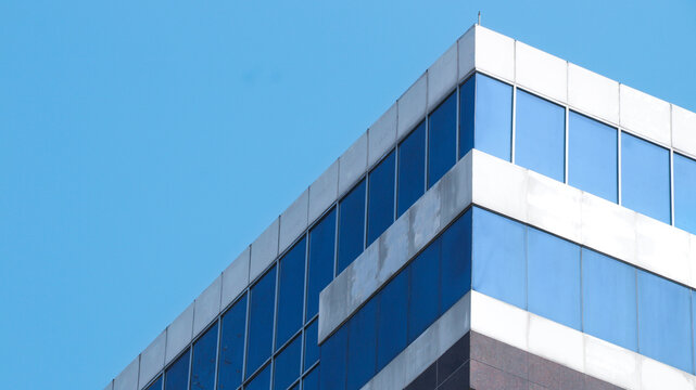 Abstract image of looking up at modern glass and concrete building. Architectural exterior detail of office building.
