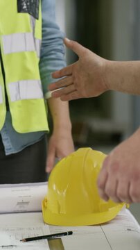Architecture, handshake and people with blueprint, construction site and meeting for project. Communication, inspector and engineering with team, paperwork and shaking hands with building development