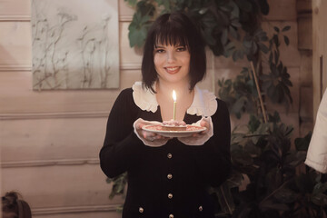 birthday cake with one candle, a girl makes a wish on her birthday