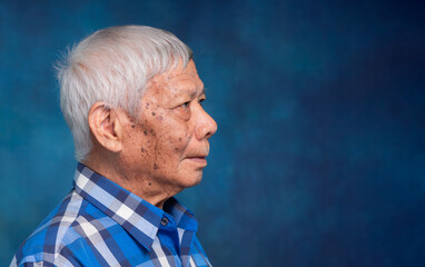 Senior man side profile portrait with gray hair on dark background. © meeboonstudio