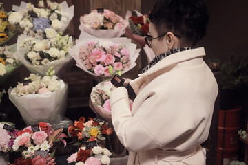 a woman chooses a bouquet of flowers in a flower shop