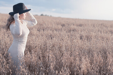 Summer Look female model posing in a field against the sky, the concept of natural freedom and femininity