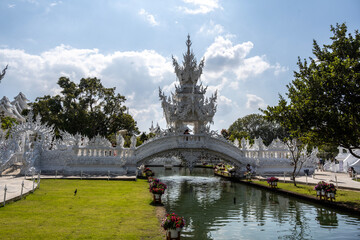 Fototapeta premium A white Buddhist temple against a blue sky in the outskirts of Chiang Mai