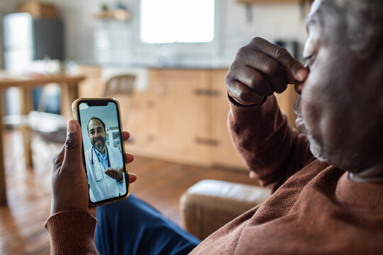 Older man having telehealth consultation with doctor at home