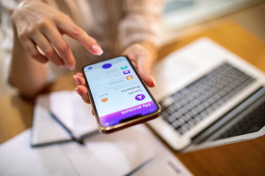 Woman using mobile banking app at home office