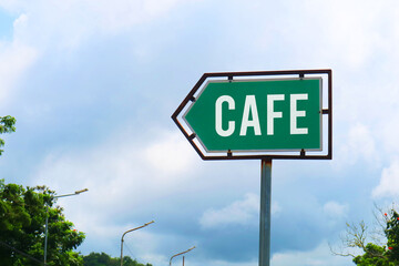 Cafe Road Sign with Dramatic Clouds and Sky.