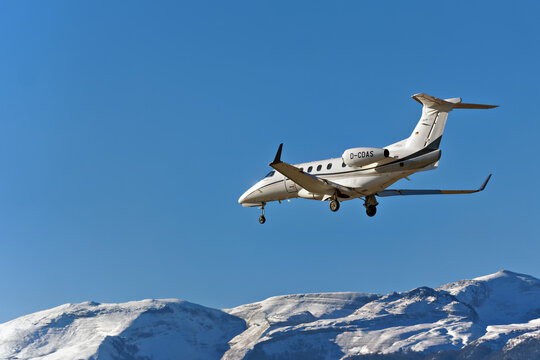 Geneva, Switzerland - january 03, 2026 : signs and logotype on an Embraer Phenom 300 of DAS Private Jets landing at Geneva Airport with Snow-covered Jura mountains 