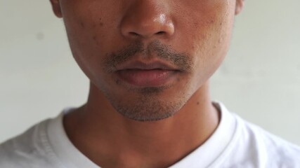 Close up of a young Asian man is smoking using vape electric cigarette, isolated by white background.
