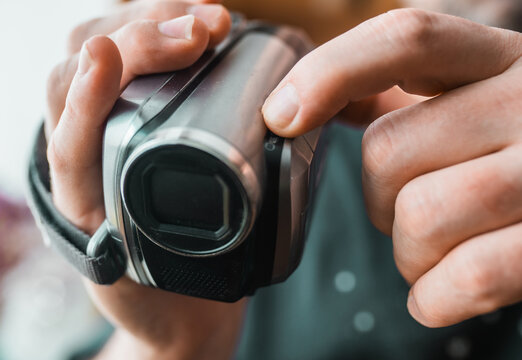 Hand with retro camcoder with LCD flip screen.