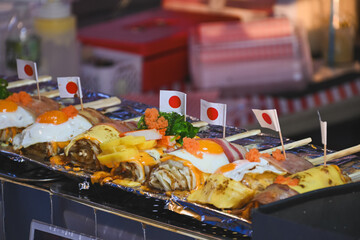 Assorted Japanese-style street food rolls topped with fried eggs.