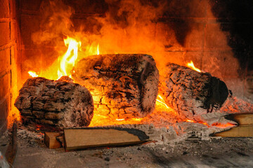 A fire is burning in a fireplace with three logs