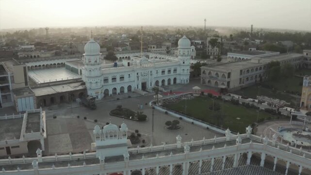 Aerial view of a beautiful white gurdwara and its reflection in a courtyard pool