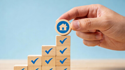 Hand putting house block checklist stack representing confident property decision making process regarding real estate investment or mortgage loan