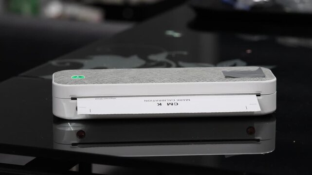 Thermal printer printing on thermal paper with high-pitched buzzing and rapid line-feed movement sound.