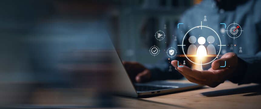 Businessman uses a laptop to target and select key personnel using digital technology. The image conveys an HR strategy focused on finding the right employees to drive the organization towards future 