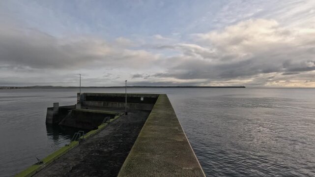 Fast motion POV walking along concrete breakwater at quiet ocean pier