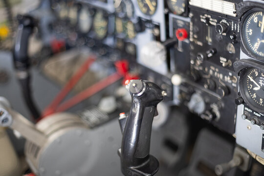 Aircraft cockpit showing flight control stick and instrument panel - Powered by Adobe