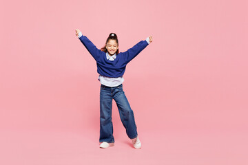 Full body little kid girl 8-9 years old wears blue shirt have fun do winner gesture celebrate clench fist isolated on pink background child studio portrait. Mother's Day love family lifestyle concept.