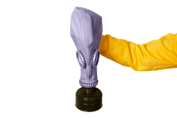 Person in yellow sleeve holding a grey gas mask, isolated on transparent background, emphasizing safety and protection themes.