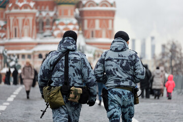 Russian soldiers in winter camouflage walking on Red Square on St Basils Cathedral background