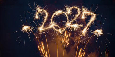 happy new year, new year's eve, silvester, new years eve, sparklers celebration greeting card, new year card - Year 2027 in sparkler font and firework fireworks pyrotechnic, blue night sky background © Corri Seizinger
