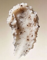 Hyper-realistic studio photography of cosmetic textures, swatch of a white sugar scrub with coffee grounds