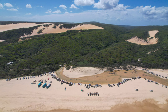 Aerial view of golden sands and a creek meeting verdant forests near Eurong, creating a striking contrast of colors and textures, Eli Creek, K'Gari Fraser Island, Queensland, Australia.