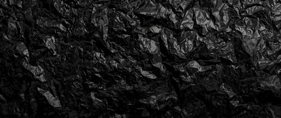 Naklejka premium Close-up shot of crinkled black foil wrap