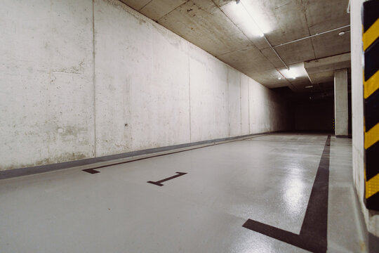 Empty underground parking tunnel with raw concrete walls and industrial urban interior