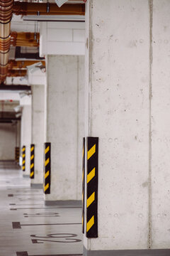 Concrete parking pillars with black and yellow safety stripes in underground garage