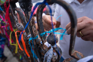 Close-up of hands on a grid with ribbons and a rosary