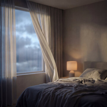 Interior of a cozy bedroom with white curtains blowing in the wind at dusk