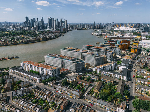Aerial view of the winding Thames, cutting through the landscape near Greenwich, with the O2 Arena and Canary Wharf piercing the skyline, London, United Kingdom.