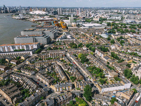 Aerial view of terraced houses and modern buildings meet in a vibrant tapestry of urban life, with the O2 Arena standing tall, Greenwich, London, United Kingdom.